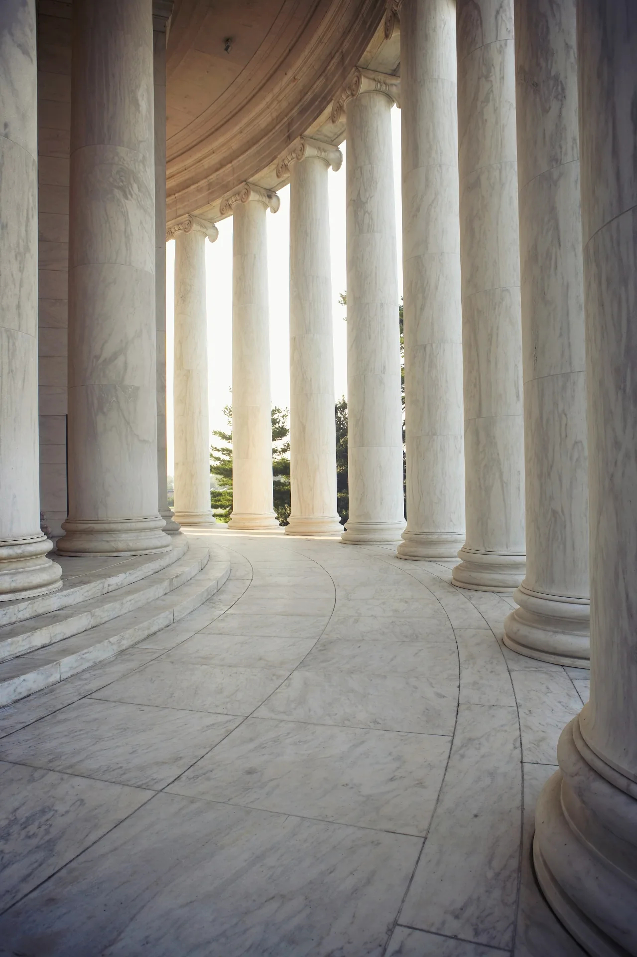 Curved marble colonnade with classical columns, the Colonnade property marketing brand motif